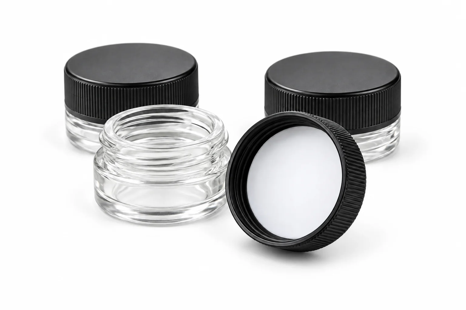Black concentrate jar lids with white PTFE liner surfaces and clear jars on a white background